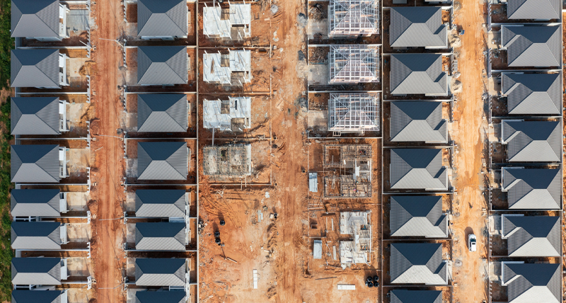 Vue aérienne d’un grand chantier de construction d’habitations, avec des rangées de maisons présentant différents  états d’avancement, illustrant la capacité du Pegasus TRK Evo à relever des données précises pour planifier la construction et l’infrastructure.